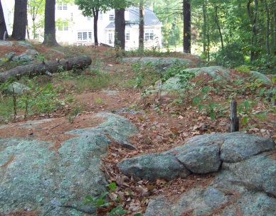 The Mack Trail runs across a rocky outcropping before descending down to the forest.