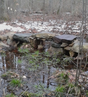 stone bridge crossing a wetland area in rockland town forest